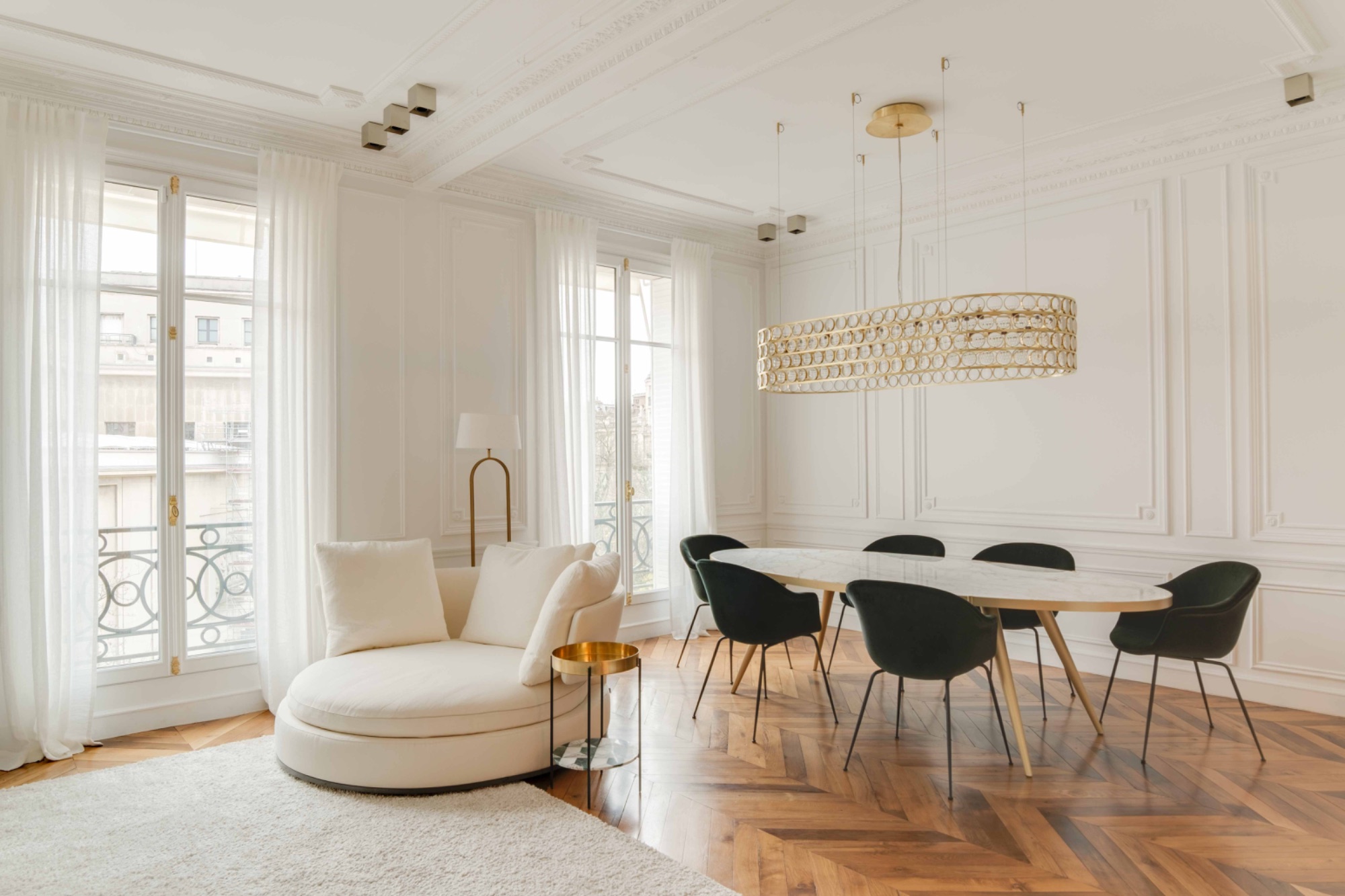 Soggiorno milanese luminoso con parquet a spina di pesce